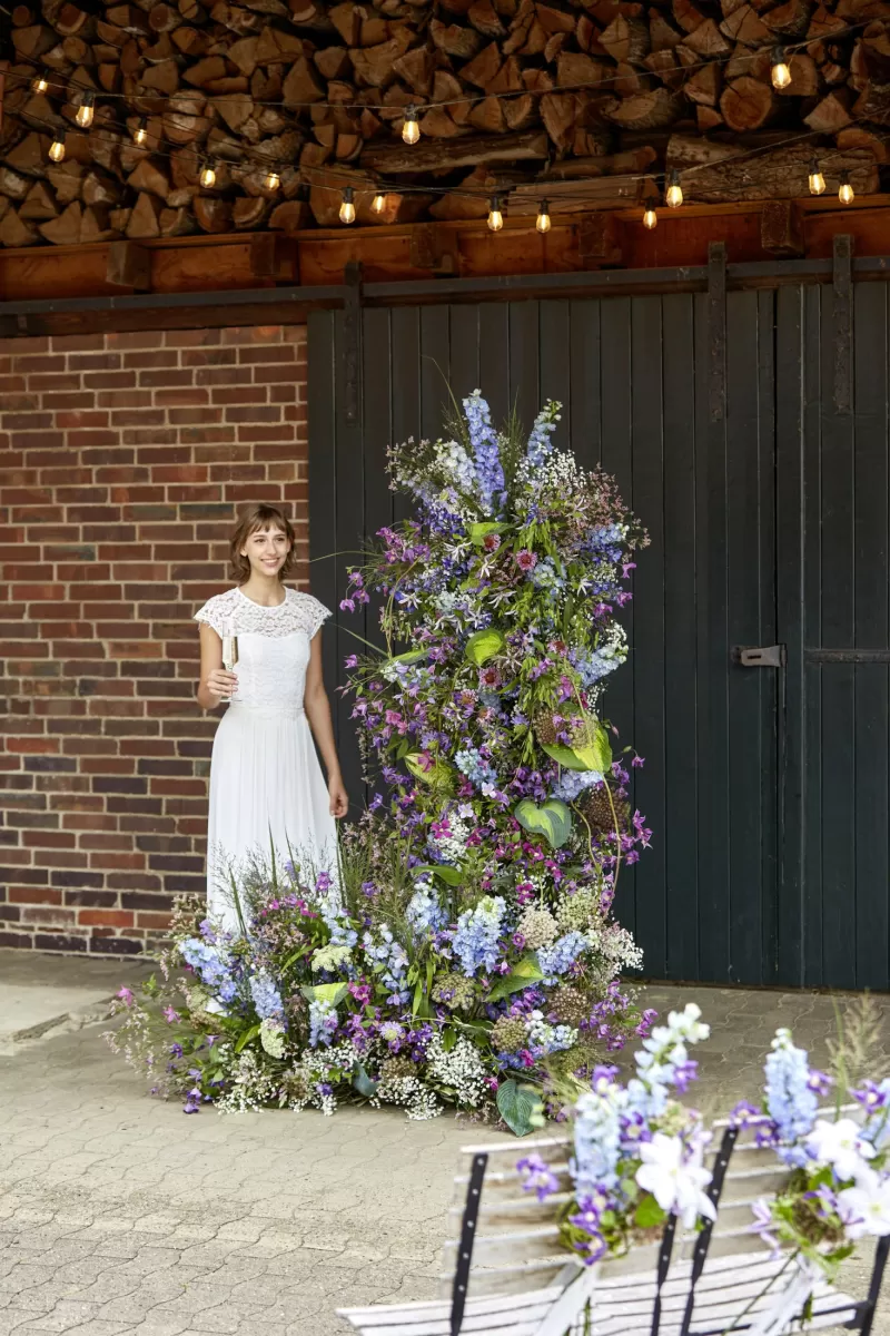 Bloemenboog bruiloft Clematis Amazing® (‘Kyiv’, ‘Miami’, ‘Blue Pirouette’, ‘Rome’, Delphinium ‘Blue Donna’, ‘Guardian Lavender’, Gypsophila ‘Xlence®, Daucus Carota ‘Dara’, Limonium ‘Princess Diamond’, Miscanthus ‘White Cloud’, Scabiosa ‘Focal Scoop™ Bicolor pink’ 